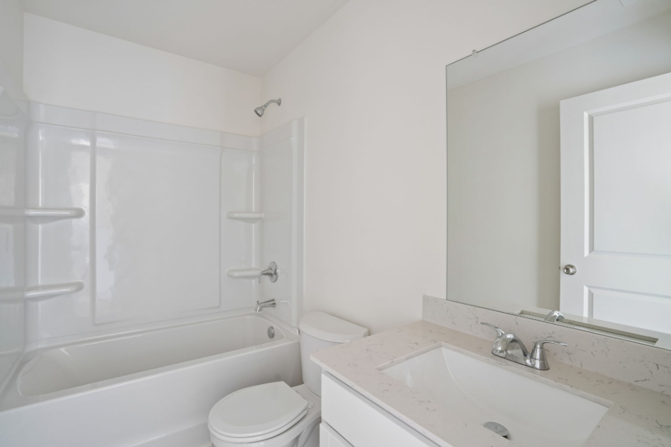 A bathroom with a tub sink and toilet.