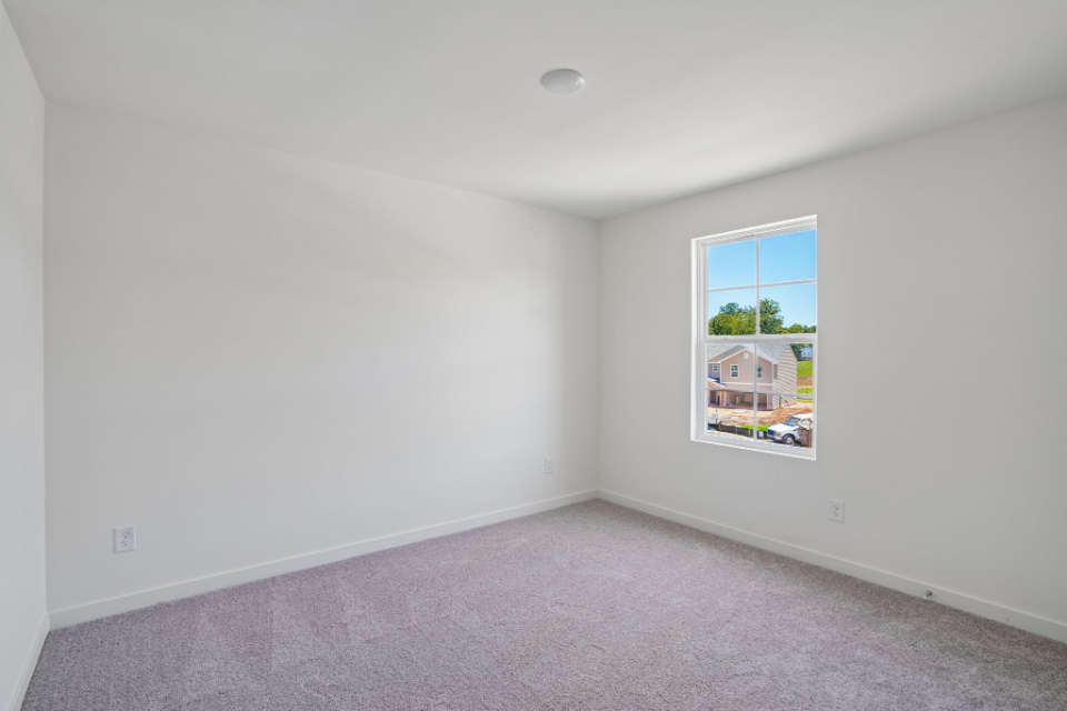 A room with a window and carpet.