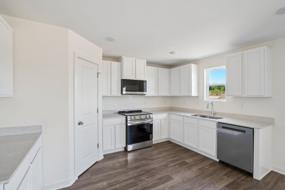 A kitchen with white cabinets.
