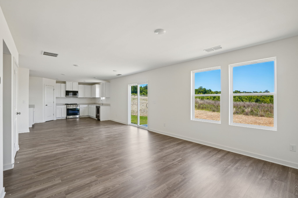A large empty room with a wood floor and white walls.