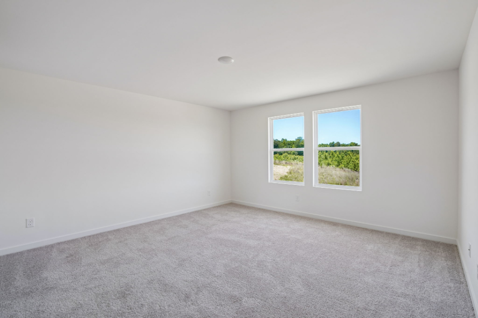 A room with a window and a carpet.