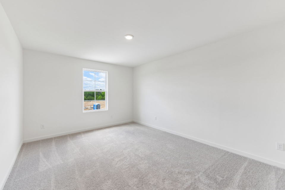 A room with a window and a carpet.
