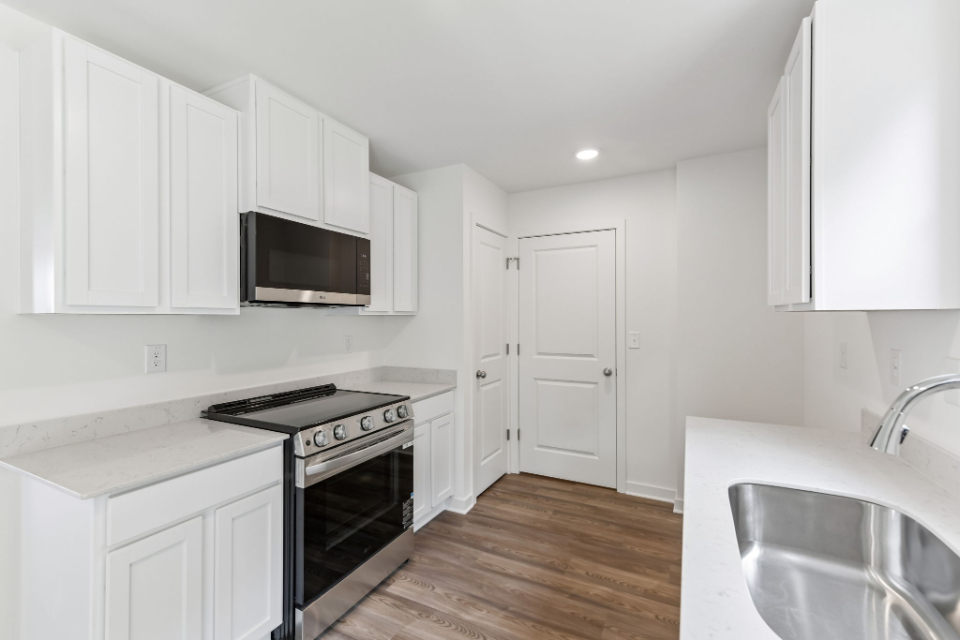A kitchen with white cabinets.