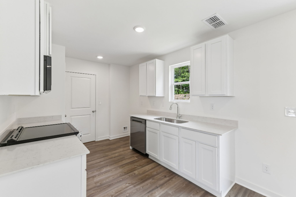 A kitchen with white cabinets.