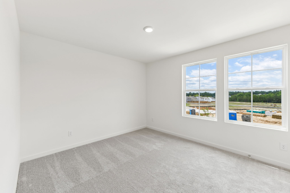 A room with a window and a wall with a view of a street.