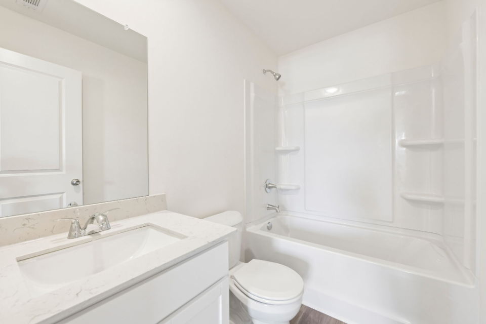 A bathroom with a tub sink and toilet.