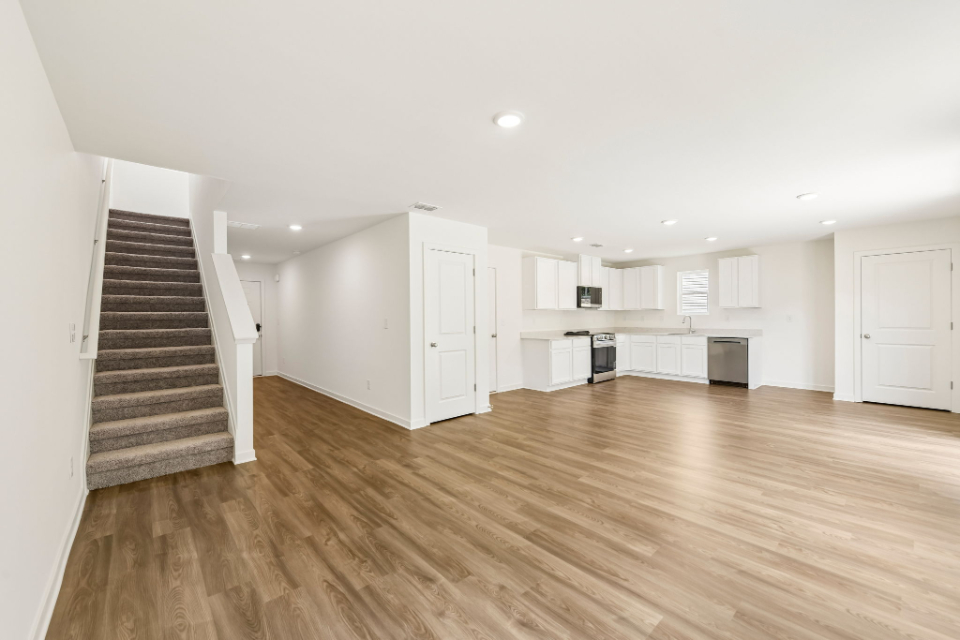 A large empty room with white cabinets.