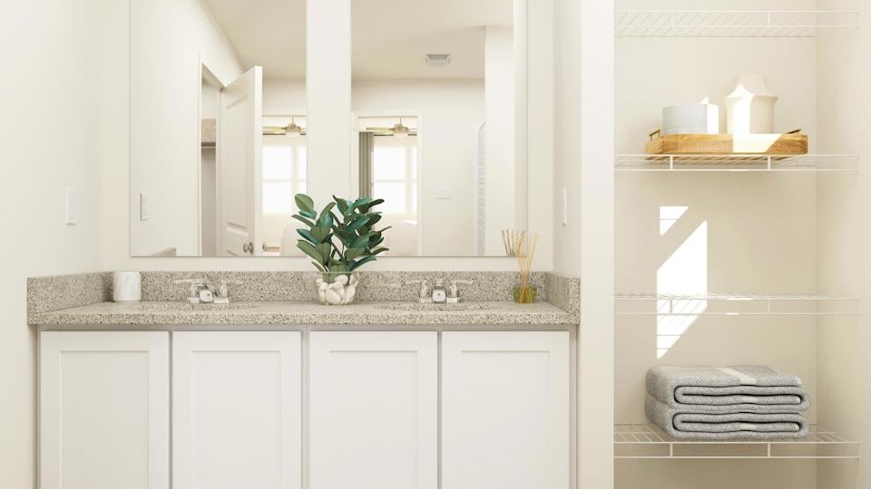A bathroom with white cabinets.