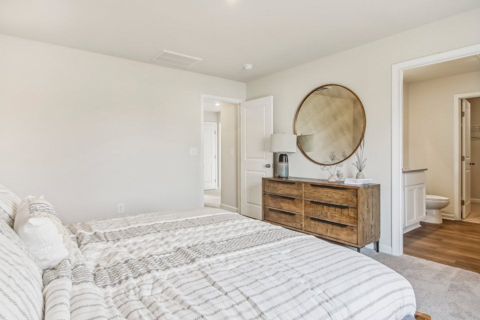 A bedroom with a large mirror.
