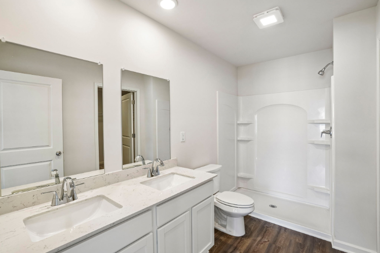 A bathroom with a toilet sink and mirror.