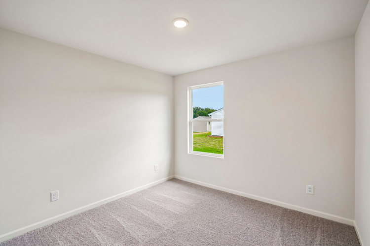 A room with a window and a carpet.