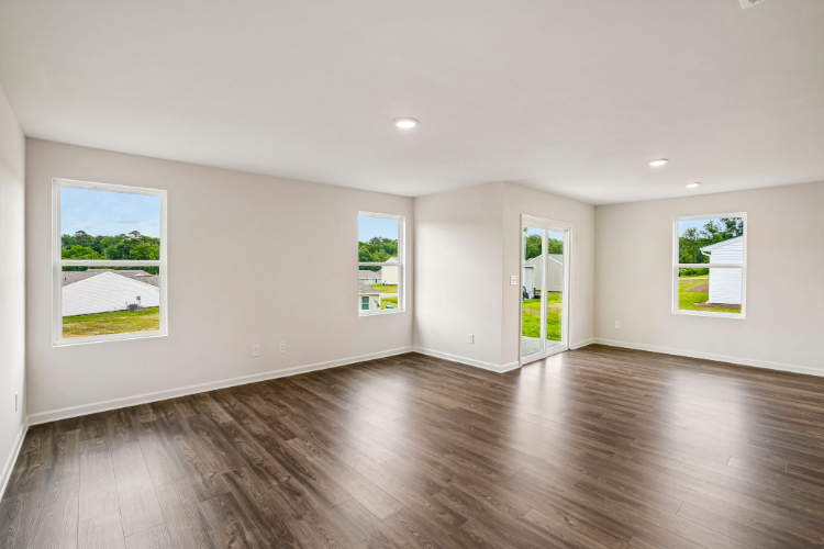 A room with a wood floor and a wood floor with a few paintings on the wall.