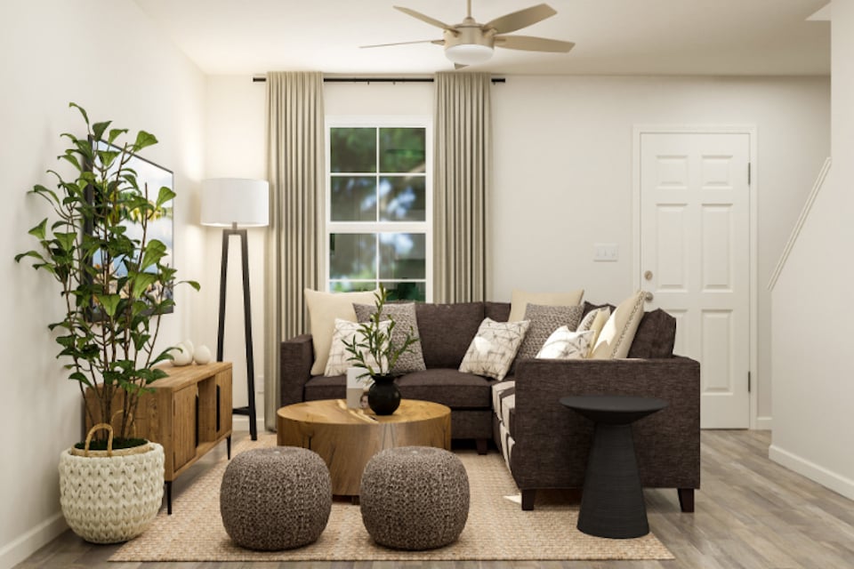 A living room with a couch and a fan.