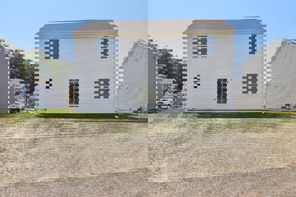 A white house with a grass yard.