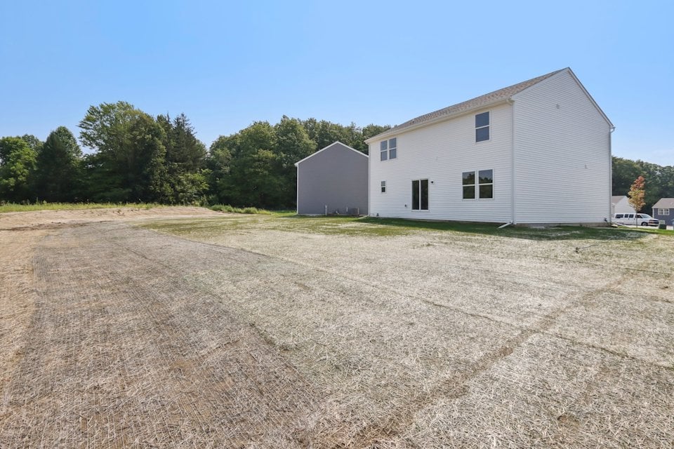 A white house with a dirt road.
