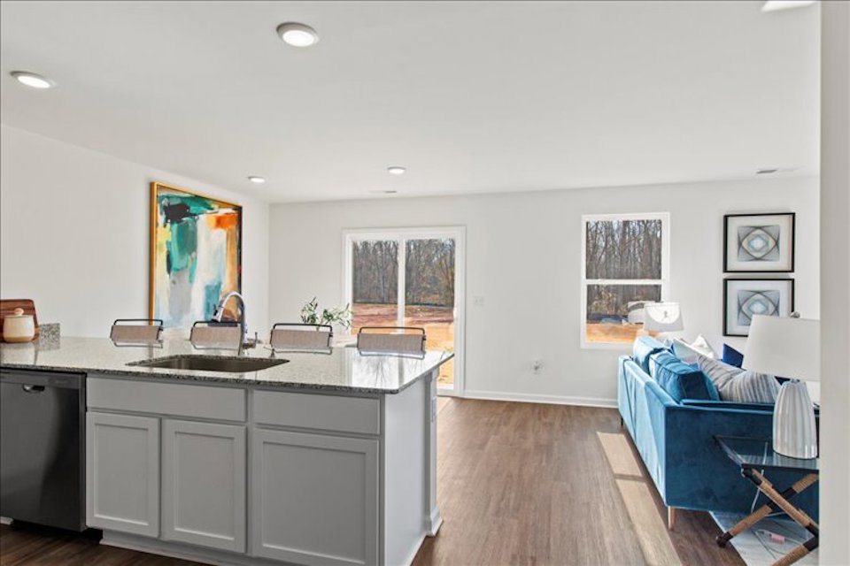 A kitchen with a couch and sink.