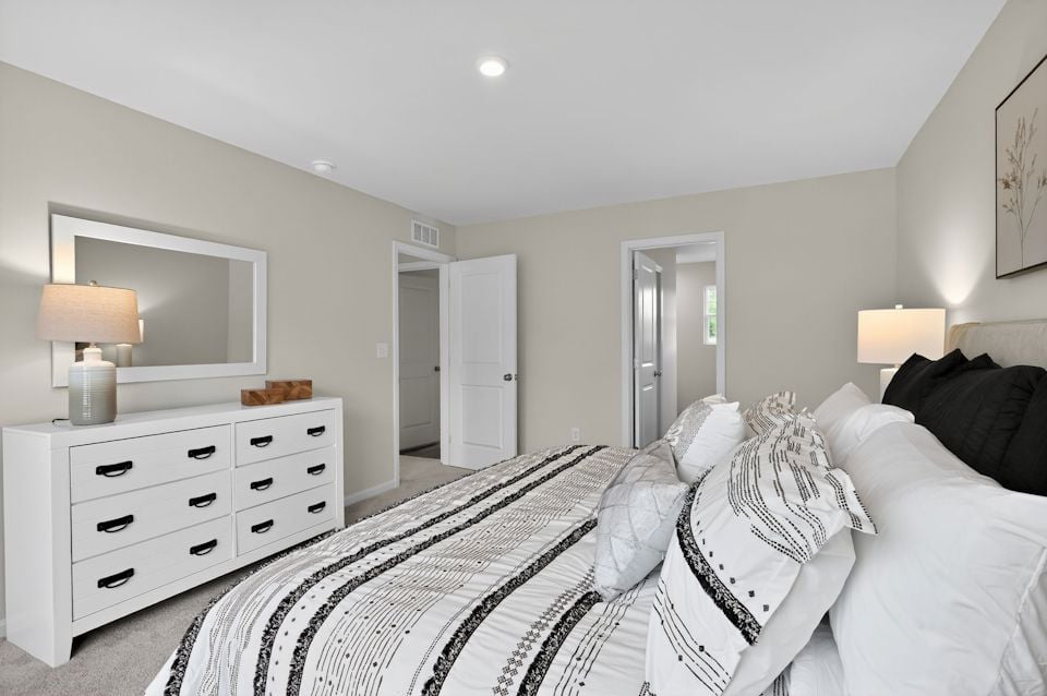 A bedroom with a bed and a mirror.