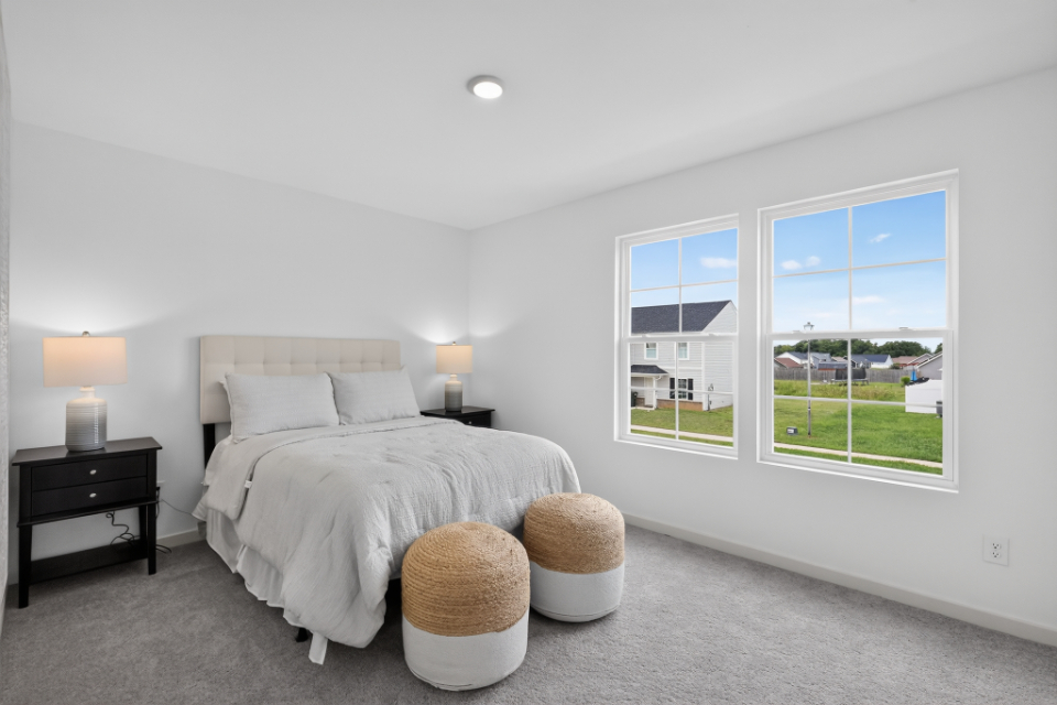 A bedroom with a bed and a window.