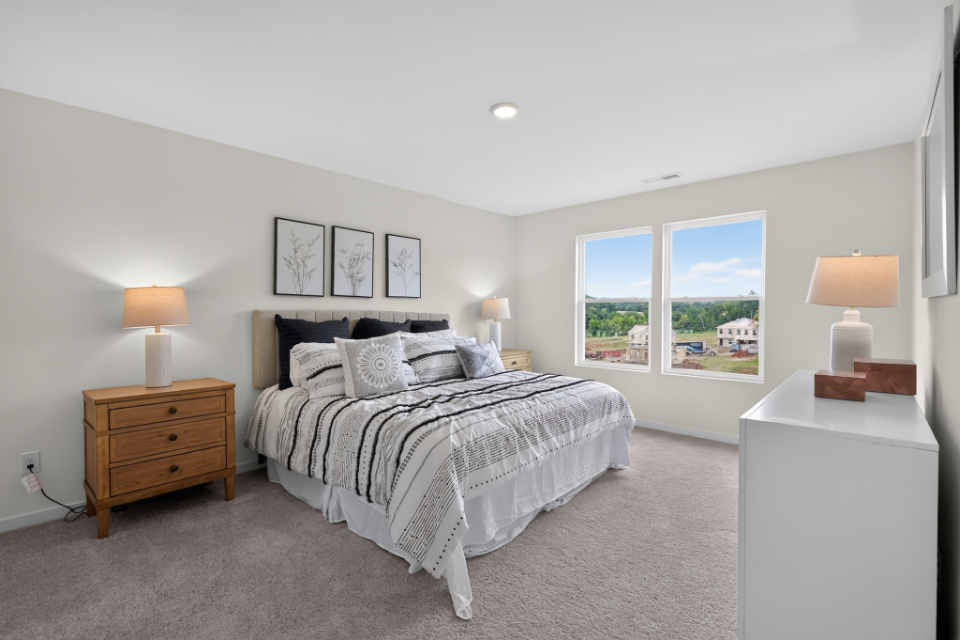 A bedroom with a bed and lamps.