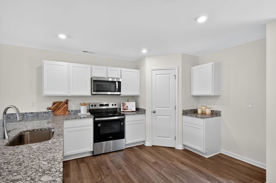 A kitchen with white cabinets.