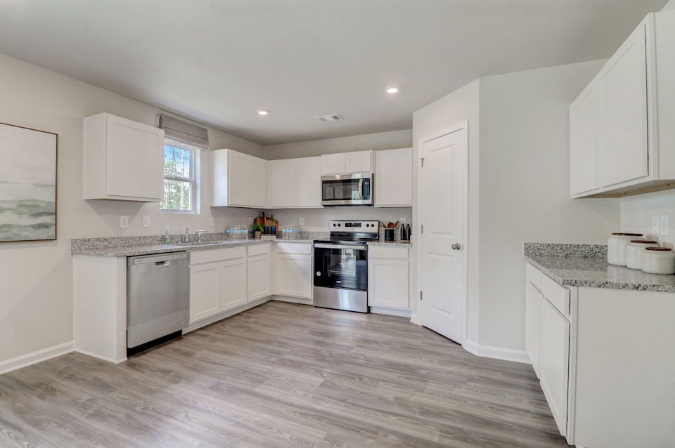 A kitchen with white cabinets.