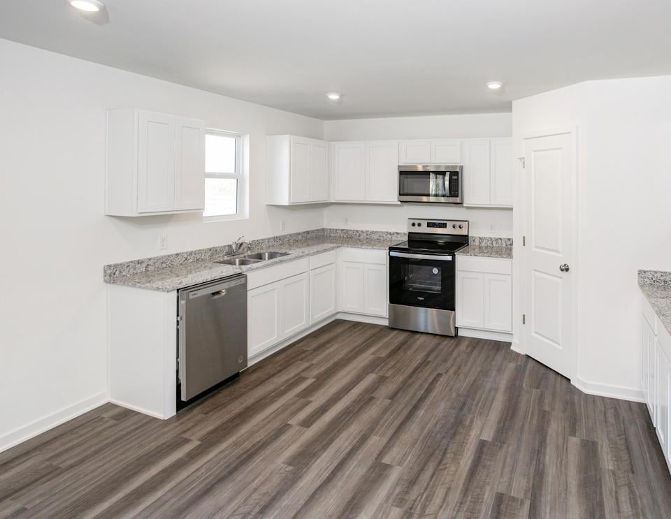 A kitchen with white cabinets.