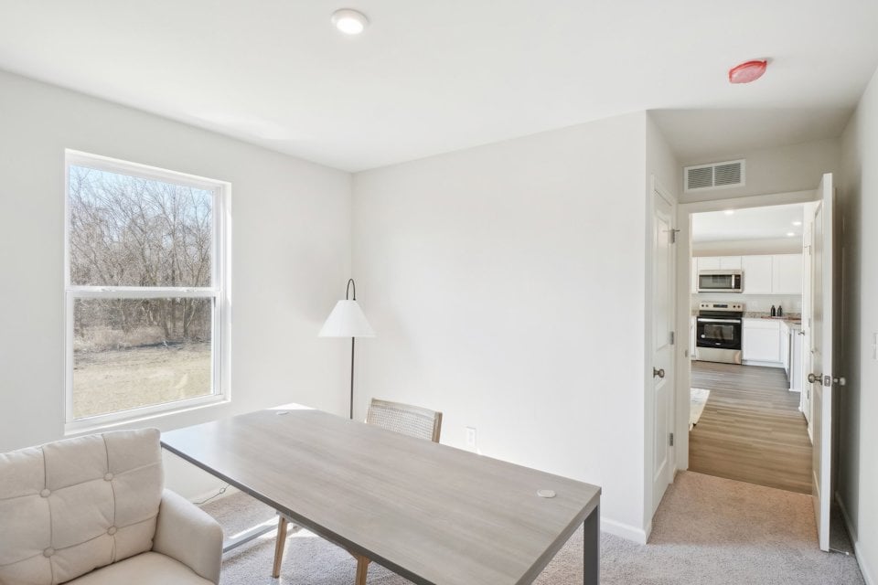 A living room with a table and chairs.