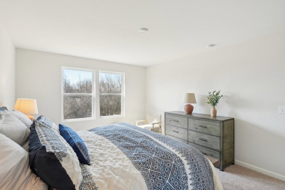 A bedroom with a bed and dresser.