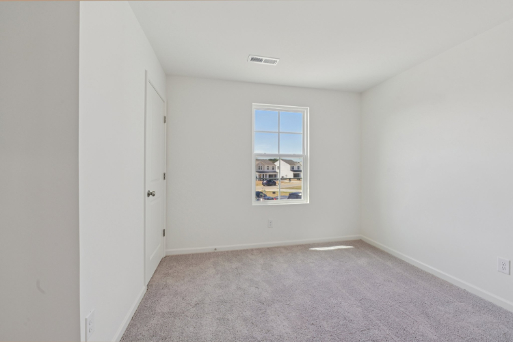 A room with a window and a carpet.