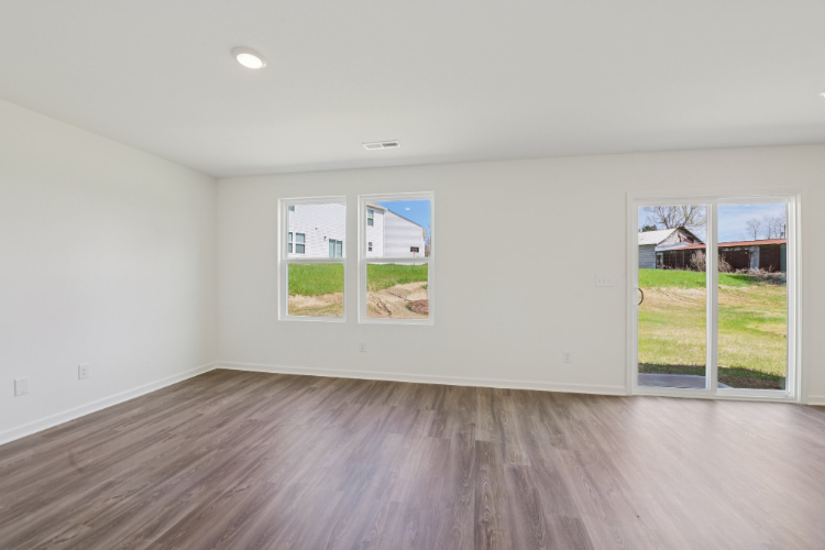 A room with a wood floor and windows.