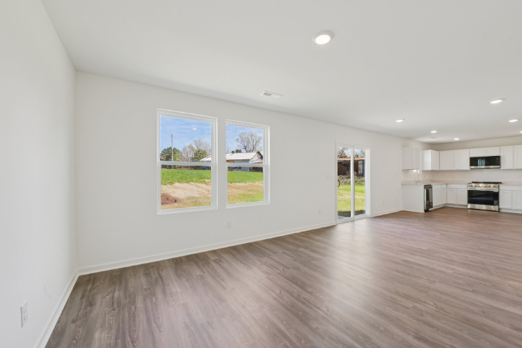 A room with white walls and a wood floor with a wood floor.