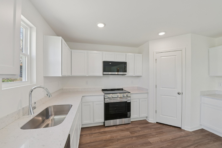 A kitchen with white cabinets.