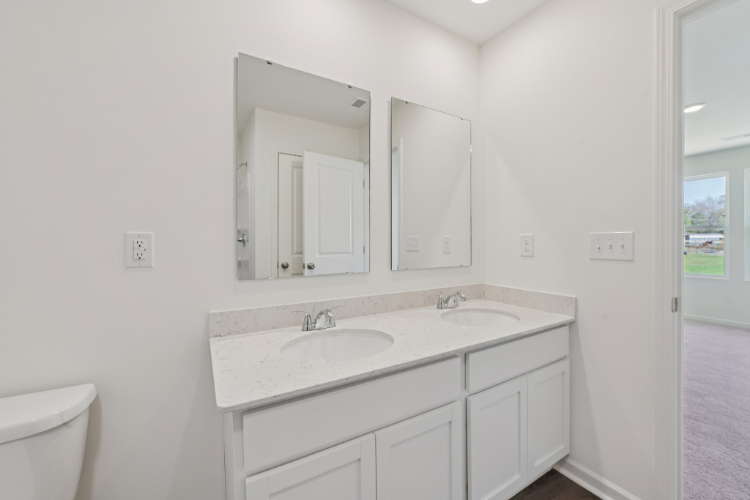 A bathroom with white cabinets.