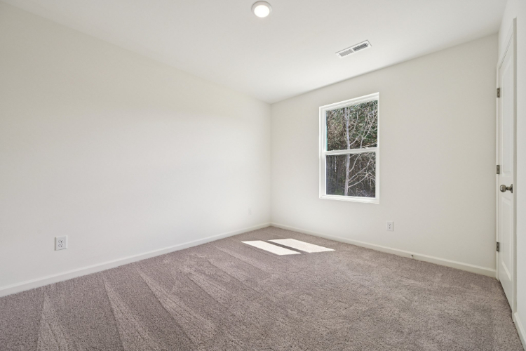A room with a window and carpet.