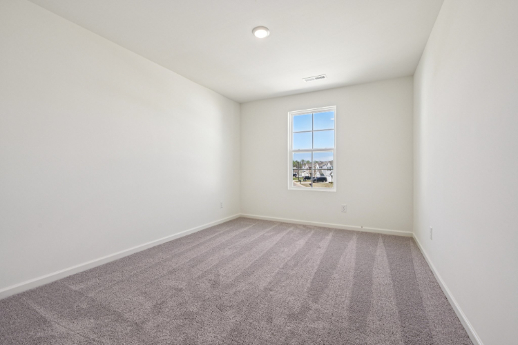 A room with a window and a carpet.