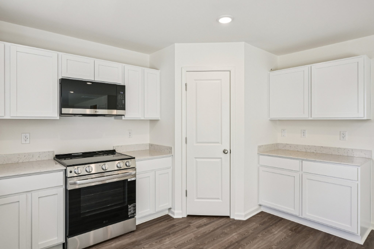 A kitchen with white cabinets.