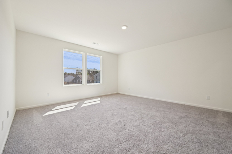A room with a carpet and a window.