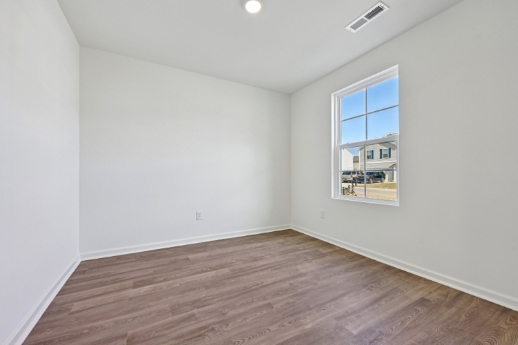 A room with a wood floor and a window.