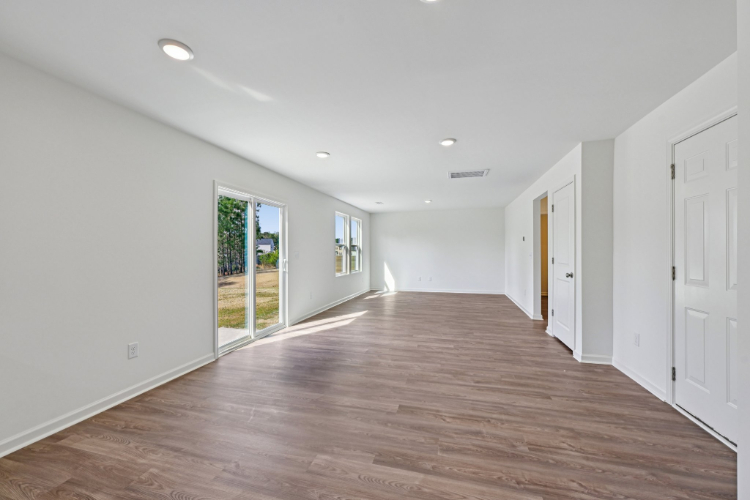 A room with white walls and wood floors.