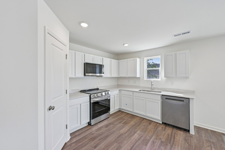 A kitchen with white cabinets.