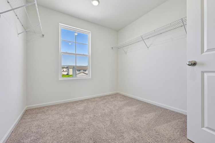 A room with a window and carpet.