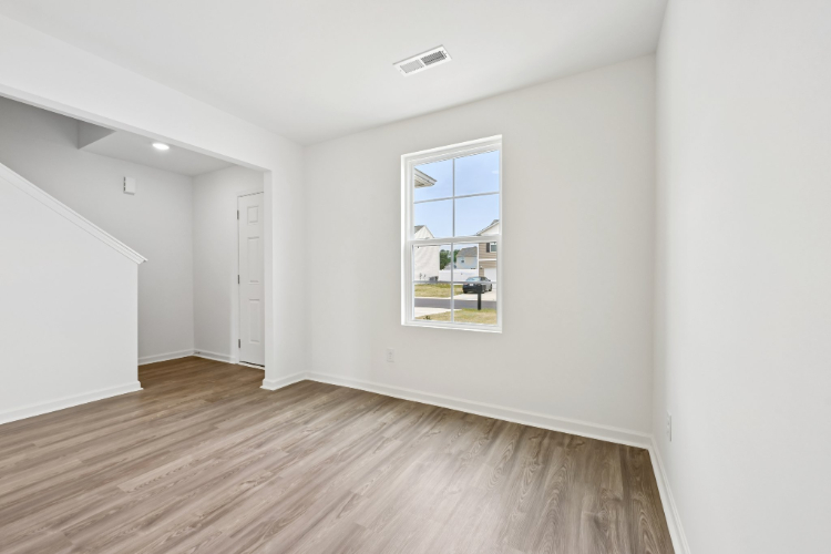 A room with a wood floor and a window.