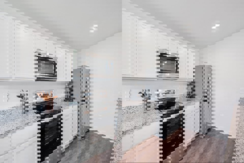 A kitchen with white cabinets.