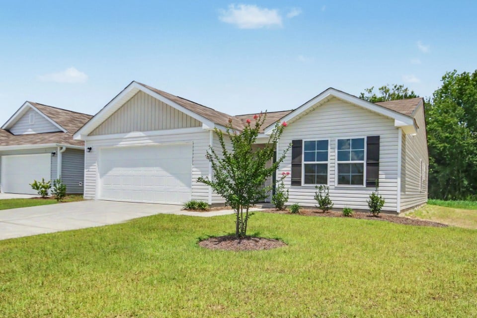 A house with a tree in the front yard.