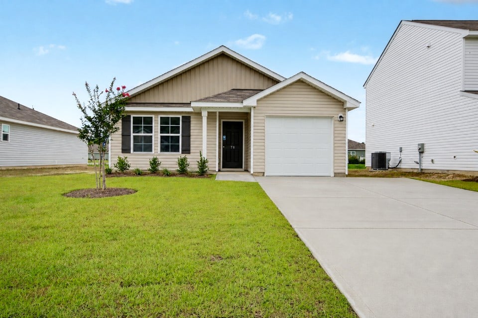 A house with a driveway with Southfork Ranch in the background.