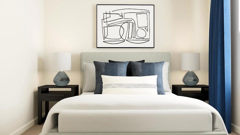 A bed with a white bed spread.