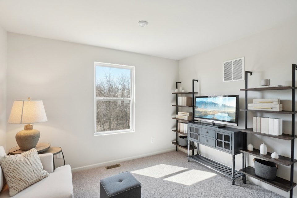 A living room with a tv and shelves.