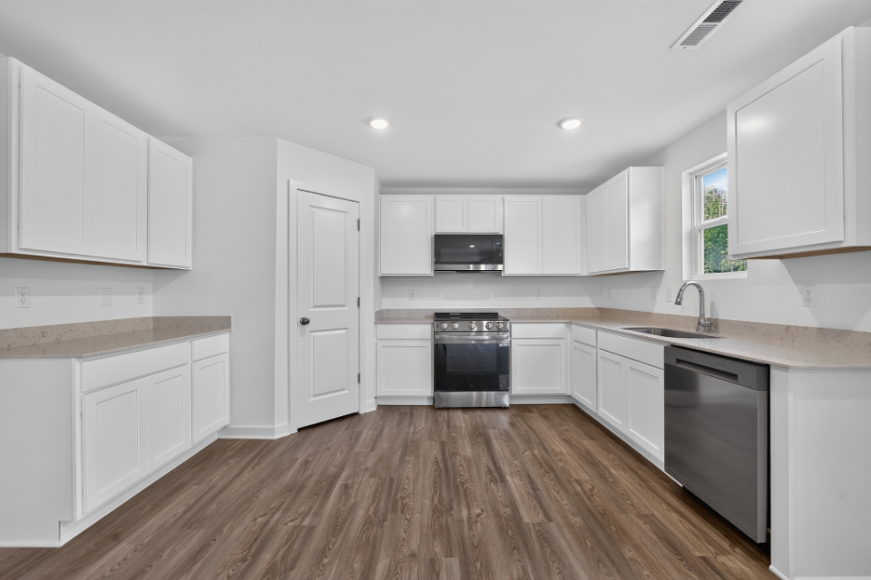A kitchen with white cabinets.
