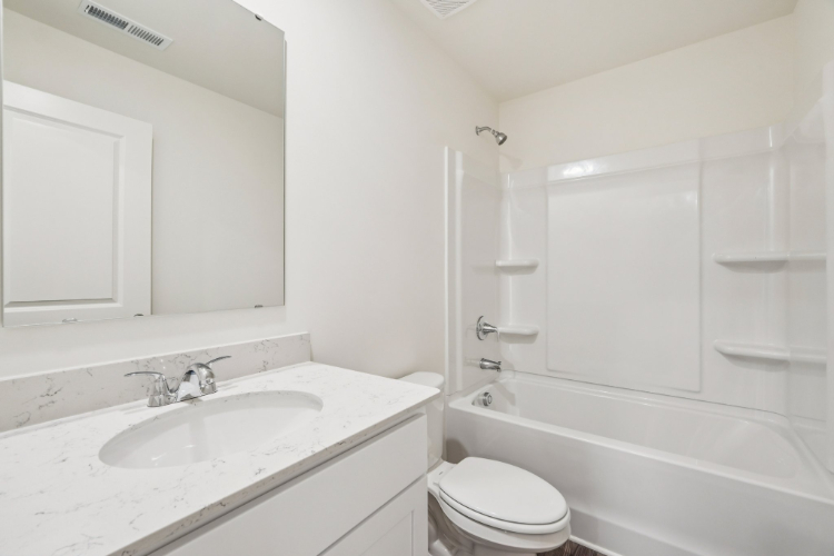 A bathroom with a sink toilet and bathtub.