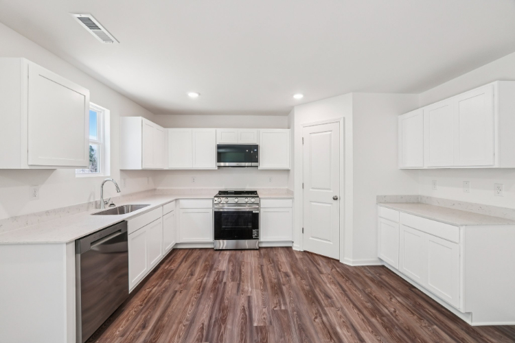 A kitchen with white cabinets.